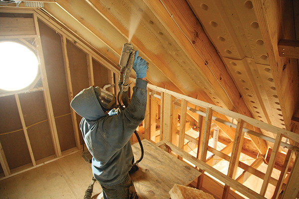 Man spraying foam in an attic