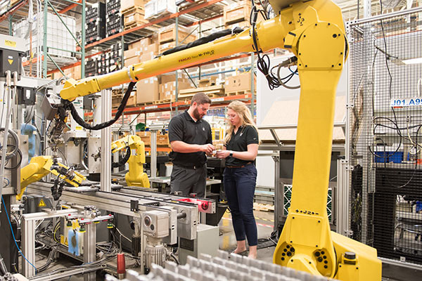 vrouw en man in de fabriek met robot